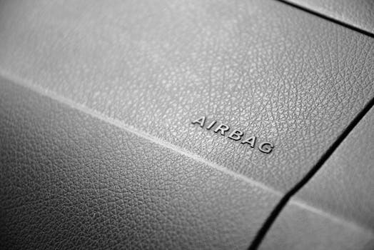 Detailed view of a leather car airbag label on a dashboard in black and white.
